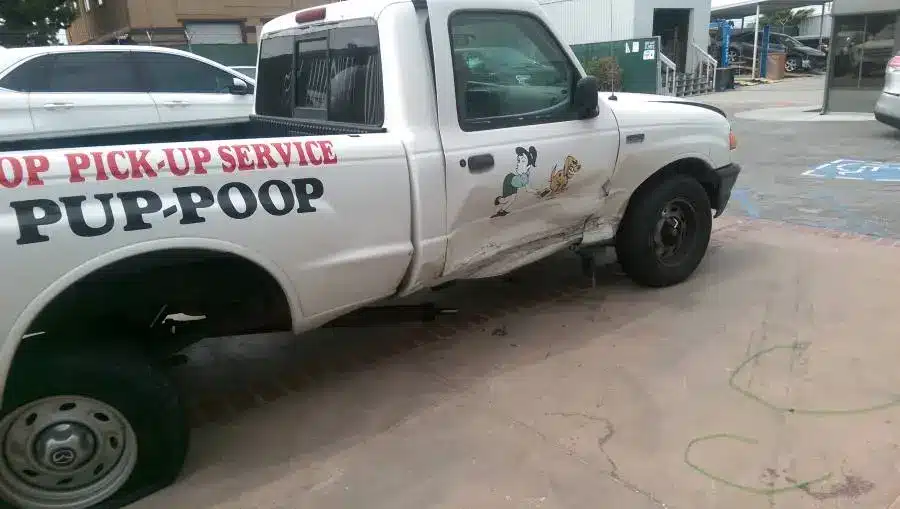 Image of an older scoop masters pet waste removal service vehicle after getting t-boned while on the job.