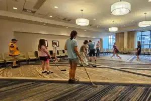 Image of visually impaired people playing blind hockey in hotel for a demonstration. Posted by Scoop Masters pet waste removal service